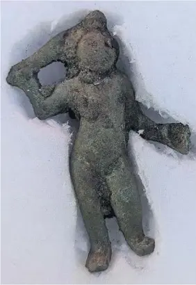  ?? Highways England ?? Discovered during survey work for the A417 Missing Link, the figurine of the Roman god, Cupid. Below, the brooch found at the same site