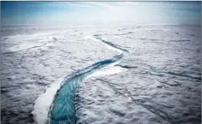  ?? JOSH HANER/THE NEW YORK TIMES ?? Meltwater flows along a supraglaci­al river on the Greenland ice sheet, one of the biggest and fastest-melting chunks of ice on Earth, on July 19, 2015.