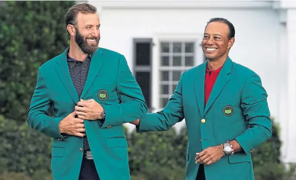  ??  ?? Dustin Johnson is all smiles after receiving his Green Jacket from outgoing champion Tiger Woods.