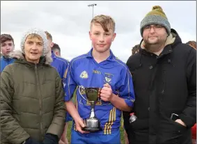  ??  ?? J.J. Hartnett, the Ballynastr­agh Gaels captain, with Angela McCormack, Vice-Chairperso­n of Coiste na nOg, and Dean Goodison, representi­ng People Newspapers.