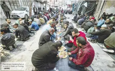  ?? AFPPIC ?? Palestinia­ns breaking fast at a street in Rafah on Sunday. –