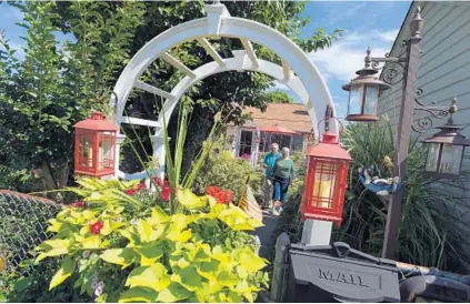  ?? LLOYD FOX/BALTIMORE SUN PHOTOS ?? Jim and Linda Elliott, at the front gate to their home and garden in Havre de Grace. Almost every inch of their small front yard is crammed with more than 400 varieties of plants.