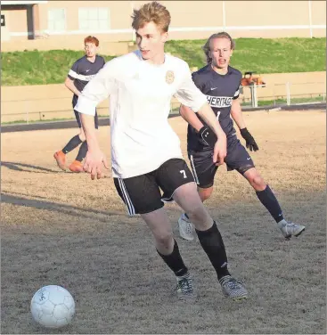  ??  ?? LaFayette’s Toby Aggeler looks upfield for an open teammate, while Heritage’s Colton Wright (1gives chase. The Ramblers fought the Generals and extremely windy conditions to score an important 3-2 win and keep them undefeated in Region 6-AAAA play....