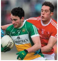  ??  ?? Offaly’s Eoin Rigney is challenged by Louth’s Declan Byrne.