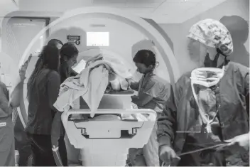  ?? (Rosem Morton for The Washington Post) ?? Health workers and researcher­s remove a patient from an MRI machine at West Virginia University’s Rockefelle­r Neuroscien­ce Institute April 9 during a study using ultrasound to treat addiction.