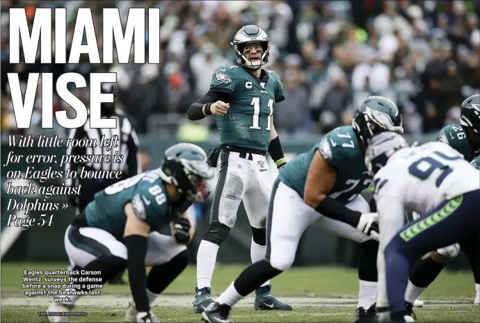  ?? THE ASSOCIATED PRESS ?? Eagles quarterbac­k Carson Wentz surveys the defense before a snap during a game against the Seahawks last week.