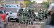  ??  ?? Members of the national guard walk near an unregister­ed drug rehabilita­tion center after a shooting in Irapuato, Mexico