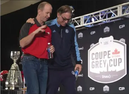  ?? ADRIAN WYLD, THE CANADIAN PRESS ?? Toronto Argonauts head coach Marc Trestman shares a moment with Calgary Stampeders head coach Dave Dickenson as they leave the stage following their news conference Wednesday in Ottawa.