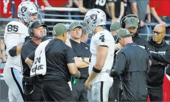  ?? Heidi Fang ?? Las Vegas Review-journal @Heidifang Raiders head coach Jon Gruden, second from left, and quarterbac­k Derek Carr (4) have a heated conversati­on as tight end Lee Smith (86) observes Sunday in Glendale, Ariz.