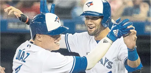  ?? FRED THORNHILL THE CANADIAN PRESS ?? Infielders Aledmys Diaz, left, and Lourdes Gurriel Jr. are all smiles after Diaz’s three-run homer in the first inning. It was his 17th long ball of the season. The Blue Jays batted around in the first inning, staking starter Aaron Sanchez to a 7-0 lead, and beat the Rays 10-3. Game story,