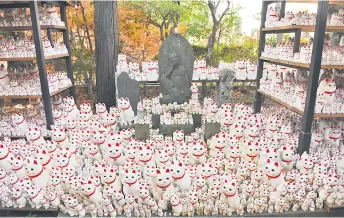  ?? ?? Thousands of waving maneki-neko cats beckon at Gotokuji temple.