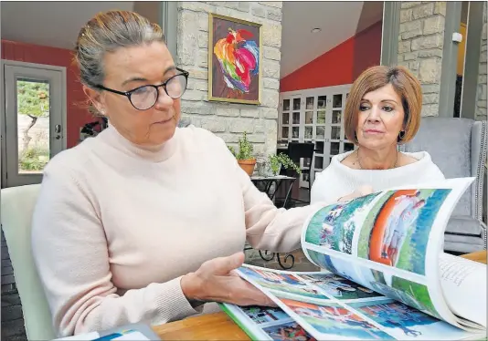  ?? [TOM DODGE/DISPATCH] ?? Annie Cacciato, left, shows Patti Busch a book made by her art-education nonprofit group. The nonprofit was housed in a building found to have radon, an invisible, radioactiv­e gas, at six times the level deemed safe.