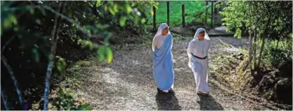  ??  ?? Fellow nuns of Maria Valentina de los Angeles walk at a convent.