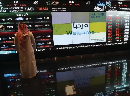  ??  ?? A Saudi investor monitors the Saudi Stock Exchange. GDP is expected to rise 1.1 per cent next year