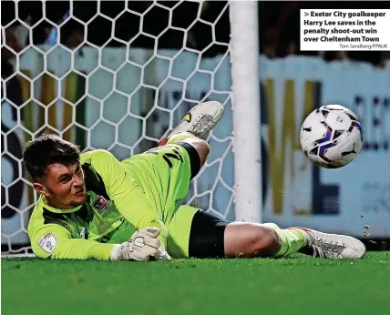  ?? Tom Sandberg/PPAUK ?? > Exeter City goalkeeper Harry Lee saves in the penalty shoot-out win over Cheltenham Town