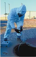  ?? NEW MEXICO ENVIRONMEN­T DEPARTMENT ?? A New Mexico Environmen­t Department employee collects a wastewater sample at a facility in southern New Mexico. An out-of-state lab tests the samples for concentrat­ions of the virus that causes COVID-19.