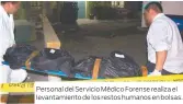  ??  ?? Personal del Servicio Médico Forense realiza el levantamie­nto de los restos humanos en bolsas.