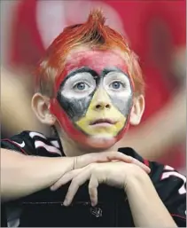  ?? Ross D. Franklin Associated Press ?? MADE UP to resemble the Arizona Cardinals’ mascot, a young fan watches the team’s victory over Tampa Bay.