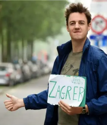  ?? FOTO JAN VAN DER PERRE ?? Met dit bordje hoopte Wout Lenders tot in Zagreb te geraken. Door zich in tankstatio­ns voor te stellen als “vriendelij­ke jongen” liftte hij tot aan de Noordkaap.