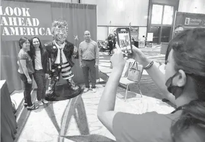  ?? JOHN RAOUX/AP ?? CPAC attendees pose for a photo next to a statue of former President Trump on Saturday in Orlando. There’s a possibilit­y Trump will run for president in 2024. But as the Trump Party takes over the GOP, anti-Trump Republican­s are abandoning the party in droves.