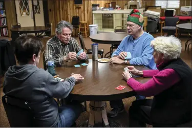  ?? PHOTOS BY NICK KING — FOR THE WASHINGTON POST ?? From left, Patty Garrett, Kent Balogh, Randy Long and Betty Gogo play euchre at the club on Dec. 28.