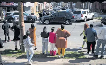  ?? AFP ?? Onlookers watch as police deal with a situation in Trenton New Jersey on Saturday after reports a gunman suspected of a shooting spree in Pennsylvan­ia was barricaded in a house.
