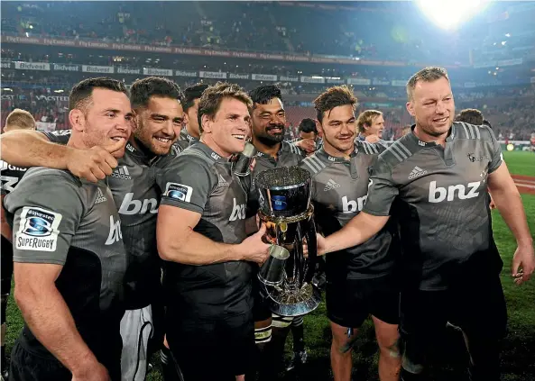  ??  ?? Matt Todd, centre, and team-mates pose with the Super Rugby trophy at Ellis Park after the final in 2017.