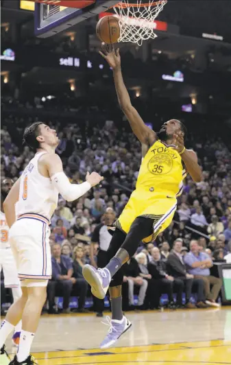  ?? Carlos Avila Gonzalez / The Chronicle ?? Kevin Durant, shown shooting against the New York Knicks’ defense, could trade in his Warriors jersey No. 35 for an orange-andblue outfit with the Knicks after this season.