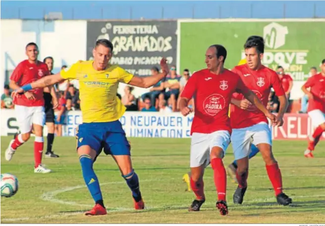  ?? MANUEL ARAGÓN PINA ?? David Querol ante dos contrarios durante el amistoso que el Cádiz jugó ante el Barbate hace dos años.