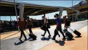  ?? JOSE SARMENTO MATOS/BLOOMBERG ?? Tourists wheel luggage May 29 from the arrivals terminal at Faro Airport in Faro, Portugal. Options for internatio­nal travel remain limited.