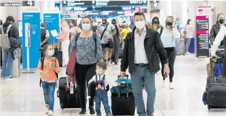  ?? MARTA LAVANDIER/AP ?? If you arrive in Florida with children, like this family in Miami, you won’t know whether the county you visit is a hotbed for a COVID variant. None of the state’s trackers includes locations about where coronaviru­s variant cases were detected.