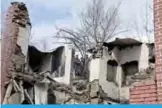  ??  ?? BALHAMA, India: Indian Kashmiri villagers look on next to the debris of a house after a gunbattle between suspected militants and government forces in the Balhama area of Khanmoh district near Srinagar. —AFP