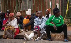  ?? Jérôme Delay/AP ?? Survivors of South Africa's deadliest fire wait outside the building on Friday. Photograph: