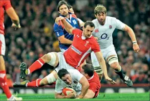  ??  ?? England's centre Brad Barritt (C) is brought down during the Six Nations internatio­nal rugby union match between Wales and England- AFP