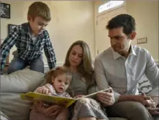  ?? Bill O'Leary/Washington Post ?? Abby and TC Maslin, right, reading with their kids Jack, 8, top left, and 2-year-old Rosie, in their Washington, D.C., home, on March 10.