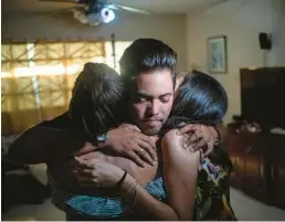  ?? RAMON ESPINOSA/AP ?? Marcos Marzo hugs two of his friends goodbye in Havana, Cuba, in January. Now in the U.S., his dream is to pursue a master’s degree at the Massachuse­tts Institute of Technology and work as an engineer, which he says is his passion.