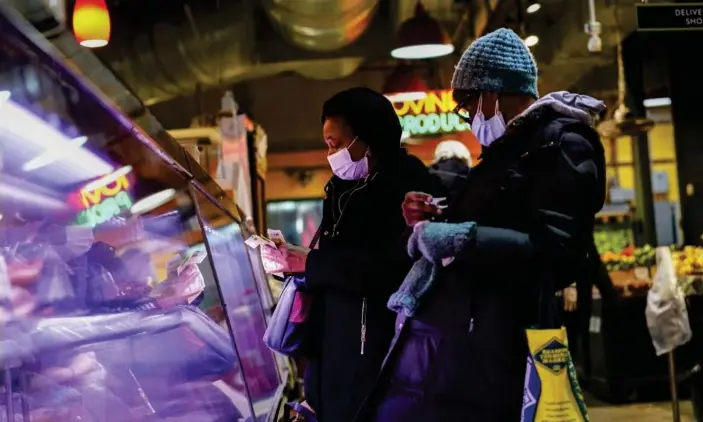  ?? ?? Customers wear face masks to protect against the spread of the coronaviru­s as they shop at the Reading Terminal Market in Philadelph­ia on 16 February 2022. Photograph: Matt Rourke/AP