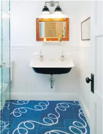  ??  ?? Left: A small master bathroom gets movie-star treatment with a state-of-the-art tub by Victoria+Albert and a sultry canvas backdrop. Right: The clean, clear colours of the tiles on this bathroom floor promise to promote a sunny outlook.