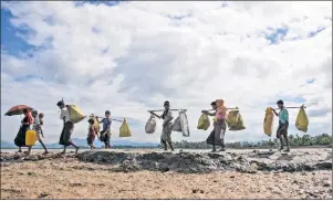  ??  ?? AP PHOTO Rohingya Muslims, who crossed over from Myanmar into Bangladesh, walk towards a refugee camp in Shah Porir Dwip, Bangladesh, Thursday. Nearly three weeks into a mass exodus of Rohingya fleeing violence in Myanmar, thousands were still flooding...