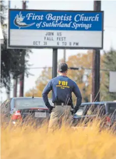  ?? FOTO: AFP ?? Ein FBI-Mitarbeite­r steht vor dem Schild der First Baptist Church in dem texanische­n Ort Sutherland Springs (USA): Hier hat ein Mann am Sonntag 26 Menschen getötet.