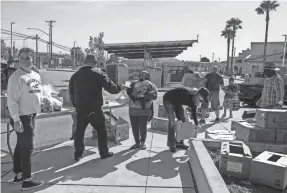  ??  ?? People pick up bags of food and cases of water during a League of United Latin American Citizens Salinas Council 2055/United Farm Workers Foundation food distributi­on in Salinas, Calif., on May 1.