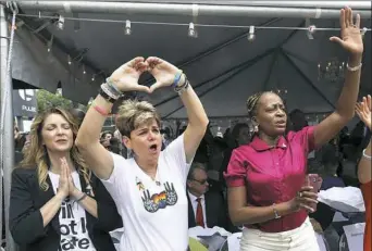  ??  ?? Barbara Poma, left, owner of Pulse nightclub, Patty Sheehan, city commission­er, and Regina Hill, city commission­er, react during a public remembranc­e ceremony Monday at Pulse nightclub in Orlando, Fla., in honor of the 49 people who lost their lives in...