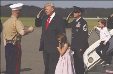  ?? EVAN VUCCI — THE ASSOCIATED PRESS ?? President Donald Trump salutes after walking down the steps of Air Force One with his grandchild­ren, Arabella Kushner, center, and Joseph Kushner, right, after arriving at Morristown Municipal Airport to begin his vacation this week in Bedminster, N.J.