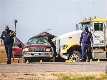  ?? THE CALIFORNIA Gina Ferazzi Los Angeles Times ?? Highway Patrol investigat­es the scene where an SUV carrying 25 people collided with a semitraile­r truck on Highway 115 near the U.S.-Mexico border, killing 13, on March 2 in Imperial County.