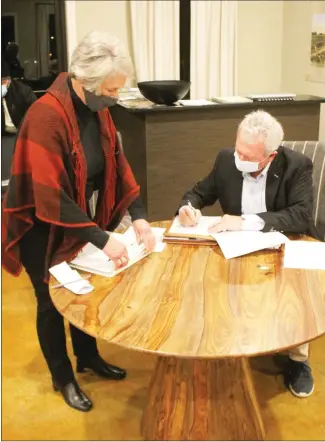  ?? Brodie Johnson • Times-Herald ?? During a special called meeting of the Delta Regional Airport Authority on Thursday, members of the board heard from members of the community as to whether the bidding process for the airports farm lease agreement was properly followed. Board member Nancy Jarratt, left watches as board secretary Mike Easley signs the lease agreement, which was awarded to Edmond Barnes.