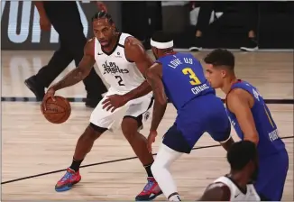  ?? KIM KLEMENT - THE ASSOCIATED PRESS ?? Los Angeles Clippers forward Kawhi Leonard (2) drives to the basket against Denver Nuggets forward Torrey Craig (3) in the first half of an NBA basketball game last week in Lake Buena Vista, Fla.