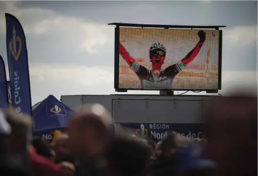  ??  ?? Hands aloft in victory on the giant screen, Dutch rider Niki Terpstra takes his first Roubaix win