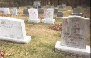  ?? Ed Miller / Associated Press ?? This photo provided by the Anti-Defamation League of Michigan shows headstones at a Jewish cemetery that were vandalized in Grand Rapids, Mich.