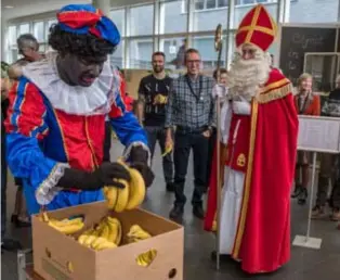  ?? FOTO JORIS HERREGODS ?? Zwarte Piet deelt bananen uit aan het douanepers­oneel.
