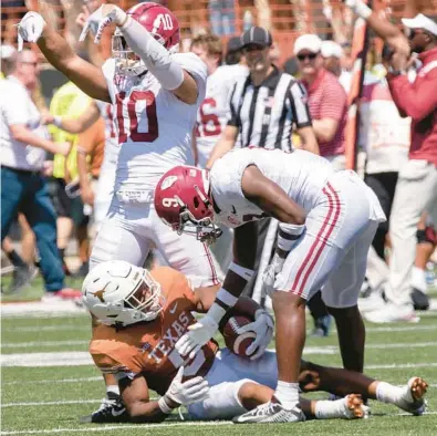  ?? RODOLFO GONZALEZ/AP ?? Alabama linebacker Henry To’oTo’o (10) celebrates the end of Saturday’s game. As time runs out for Texas and running back Bijan Robinson (5), Alabama defensive back Jordan Battle offers him a hand in Austin, Texas.